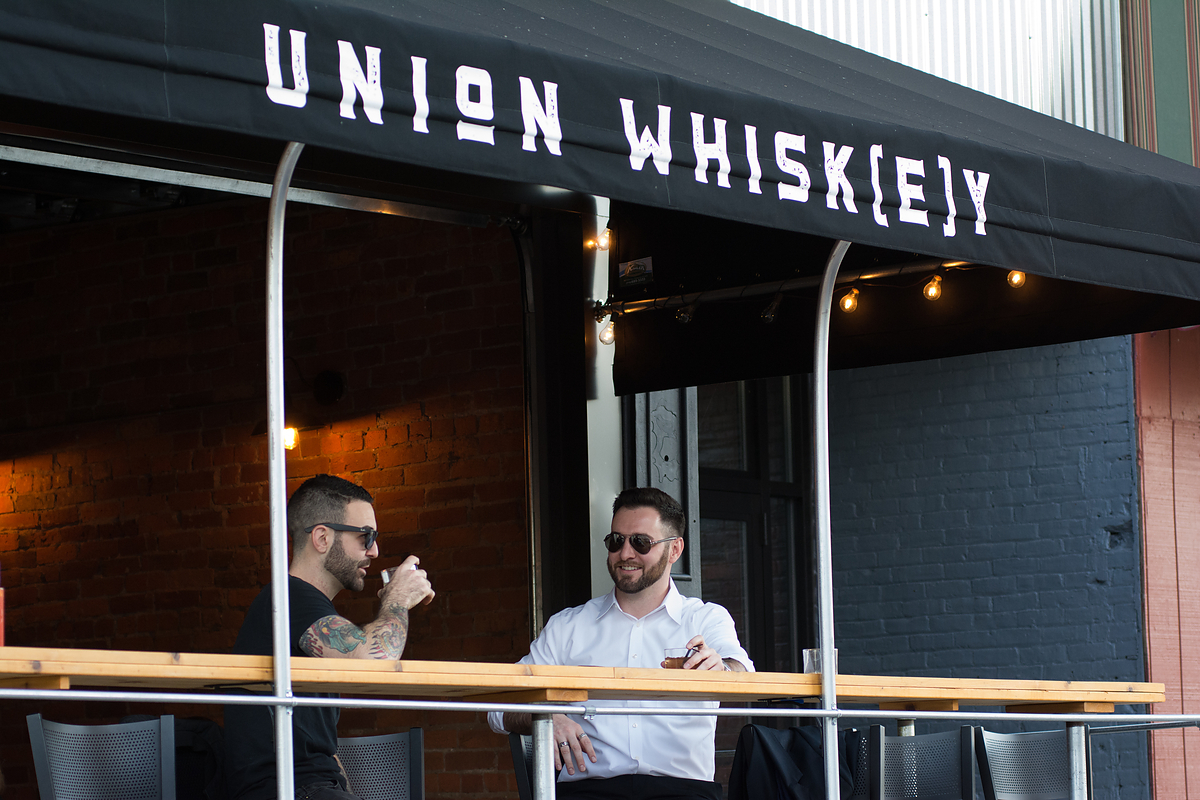 Men enjoying a drink and dinner at Union Whiskey